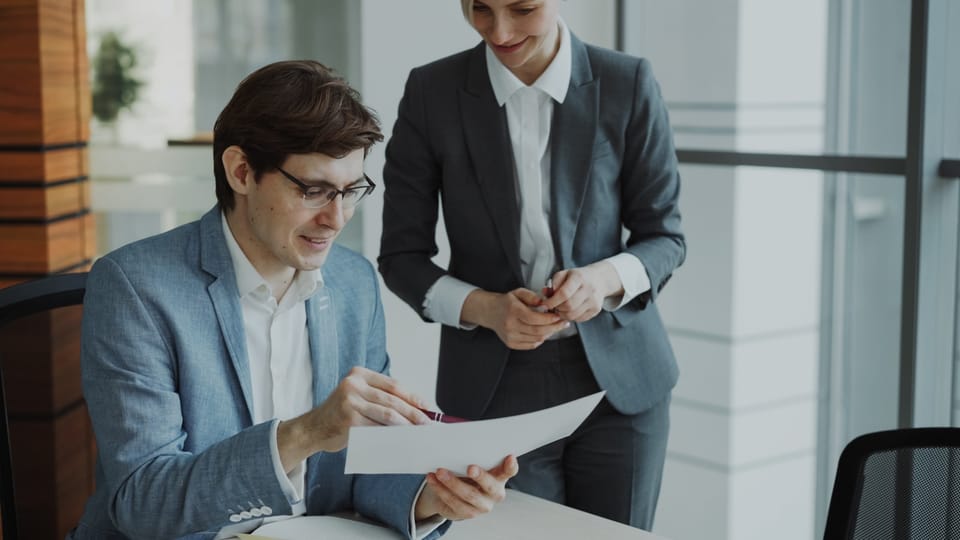 Two coworkers reviewing a document